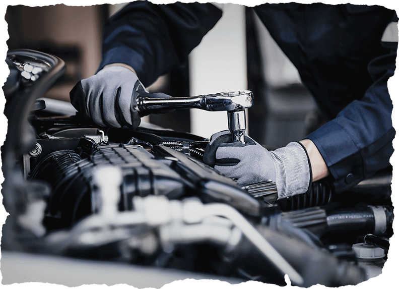 Mechanic tightening engine components with a wrench during tire service in Calgary, CA.