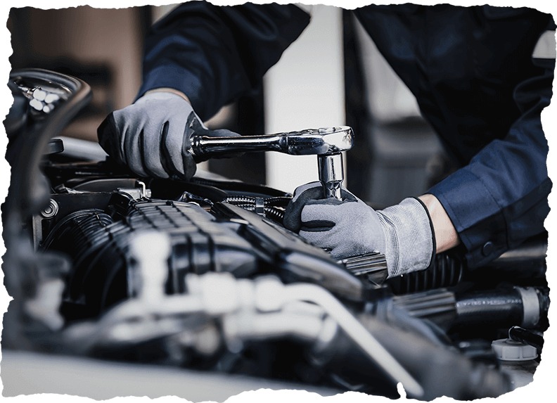 Professional mechanic working on the engine of the car in the garage by the Tire Pirates in Calgary, AB