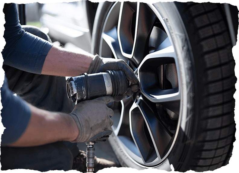 Mechanic tightening wheel bolts after Shop for Tires in Calgary, CA